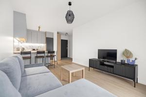 Apartament Blisko Morza Gdańsk في غدانسك: غرفة معيشة مع أريكة وطاولة