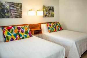 Habitación con 2 camas y 2 cuadros en la pared. en Bluff Shoal Motel en Ocracoke