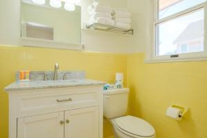 baño con aseo y lavabo y ventana en Bluff Shoal Motel en Ocracoke