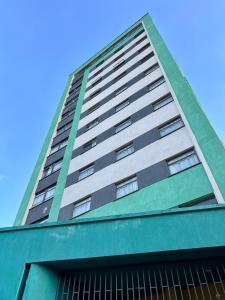 een hoog groen en wit gebouw met een blauwe lucht bij ADANA PODS in Nairobi
