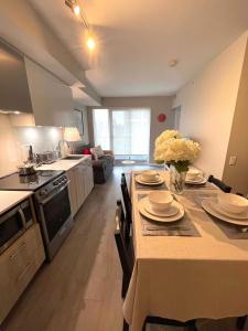 una cocina con una mesa con platos y flores. en Stunning Suite in Heart of Downtown Toronto J1, en Toronto