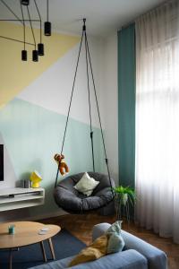 a living room with a swing chair and a couch at Modern, design lakás a Margit-sziget mellett in Budapest