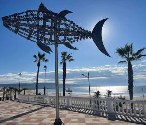 a sculpture of a fish on the beach at Apartamento Aimar Barbate in Barbate