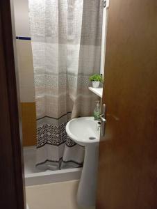 a bathroom with a sink and a shower curtain at Apartamento Aimar Barbate in Barbate