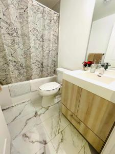 y baño con aseo, lavabo y ducha. en Stunning Suite in Heart of Downtown Toronto J1, en Toronto