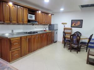 a kitchen with wooden cabinets and a table and chairs at Apartamento en Jardín-Antioquia in Jardin