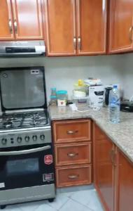 a kitchen with a stove top oven and wooden cabinets at Orient Tower - Tower C - Ajman city in Ajman 
