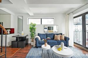 a living room with a blue couch and a table at 809-6A NEW 2BR Private Roof & City View in New York