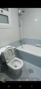 a bathroom with a white toilet in a room at Orient Tower - Tower C - Ajman city in Ajman 