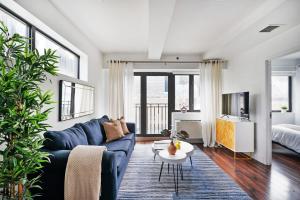 a living room with a blue couch and a tv at 809-6A NEW 2BR Private Roof & City View in New York