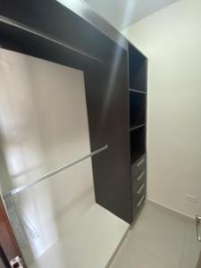 einen begehbaren Kleiderschrank mit einem schwarzen Kühlschrank in der Unterkunft Urban Retreat in ArraijÃ¡n