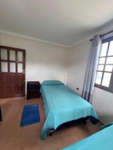 1 dormitorio con 2 camas y puerta en Casa Amigable y Confortable en Yacuíba