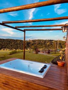 a hot tub sitting on a deck with a view at Refúgio do Sol Park Pousada - Cabana - Hospedagem 