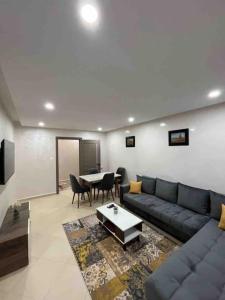 ein Wohnzimmer mit einem Sofa und einem Tisch in der Unterkunft 3 bed Akid Lotfi with parking in Bir el Djir