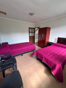 2 camas en una habitación con sábanas rosas en Casa Amigable y Confortable, en Yacuíba