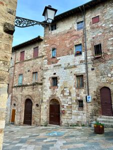 un gran edificio de ladrillo con puertas y luz de la calle en La Torre di Canonica, en Colle Val D'Elsa