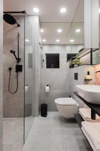 y baño con ducha, aseo y lavamanos. en AVAPARTS Apartament ROSE en Jastarnia