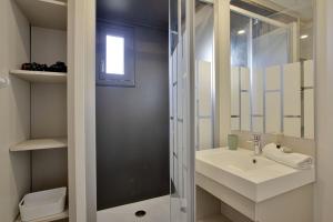 un bagno bianco con lavandino e doccia di Le Chalet Aquila - Welkeys a Saubrigues