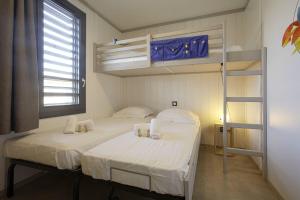 due letti in una stanza con un letto a castello di Le Chalet Aquila - Welkeys a Saubrigues