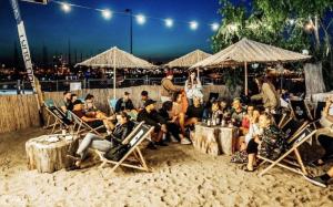 a group of people sitting in chairs on the beach at Przyczepa Mumbai in Jastarnia