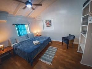 1 dormitorio con 1 cama azul y 1 silla en Pelican Inn en Talamanca