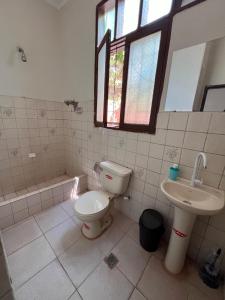 y baño con aseo y lavamanos. en Casa Amigable y Confortable en Yacuíba