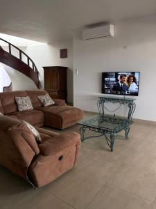 a living room with a couch and a tv on the wall at Hermosa casa a la orilla del mar in Bahía Kino