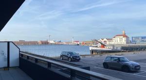two cars parked in a parking lot next to the water at Charme des quais, proche centre et plage in Dunkerque