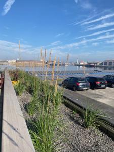 a group of cars parked in a parking lot next to the water at Charme des quais, proche centre et plage in Dunkerque