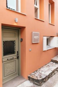 a orange building with a door and a sign on it at Jano's House in Plomarion