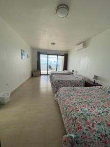 a hotel room with three beds and a window at Hermosa casa a la orilla del mar in Bahía Kino
