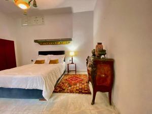 Dar Mimoun BeyにあるSuite Sidi Faouah el Meskのベッドルーム1室(ベッド1台、ランプ付きテーブル付)