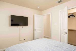 a bedroom with a bed with a flat screen tv on the wall at The Lake House in Canyon Lake