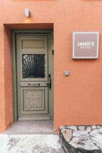 a green door with a sign in front of a building at Jano's House in Plomarion