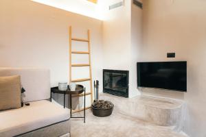 a living room with a tv and a fireplace at Jano's House in Plomari