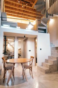 a dining room with a table and chairs and stairs at Jano's House in Plomari