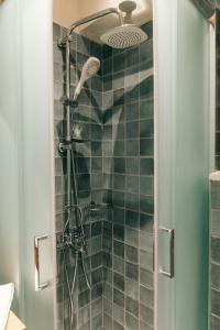 y baño con ducha y azulejos verdes. en Jano's House en Plomari