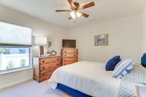 a bedroom with a bed with a ceiling fan and a dresser at Beautiful Venice Getaway, 4 Mi to Manasota Beach! in Venice
