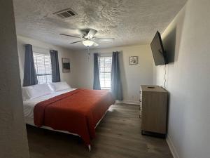 1 dormitorio con 1 cama y ventilador de techo en Spacious 5 bedroom home in Bridge City, en Bridge City