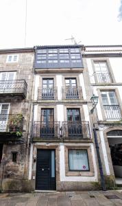 un antiguo edificio de ladrillo con ventanas y una puerta en Alda Fogar Natural, en Santiago de Compostela