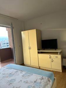 a bedroom with a bed and a cabinet with a television at Alibi ROOM's in Struga
