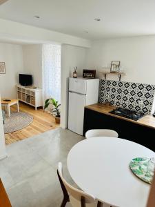 a kitchen with a table and a white refrigerator at Apartament Zatorze in Olsztyn