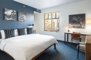 a bedroom with a large white bed and a desk at Gravity Haus Truckee-Tahoe in Truckee