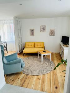 a living room with a yellow couch and a table at Apartament Zatorze in Olsztyn