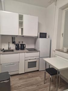 une petite cuisine avec des placards blancs et une table dans l'établissement Studio-Apartment 6, à Essen