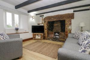 a living room with a fireplace and a tv at Myrtle Cottage in Hayle
