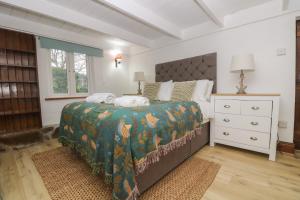 a bedroom with a bed with a green comforter at Myrtle Cottage in Hayle