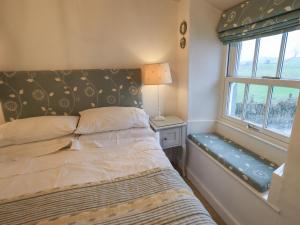 Habitación pequeña con cama y ventana en Nurses Cottage en Hawkshead