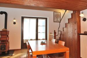 - une salle à manger avec une table et des chaises en bois dans l'établissement Appartamento SassoMalenco, à Chiesa in Valmalenco