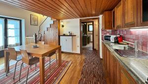 a kitchen with a wooden table and a counter top at Appartamento SassoMalenco in Chiesa in Valmalenco